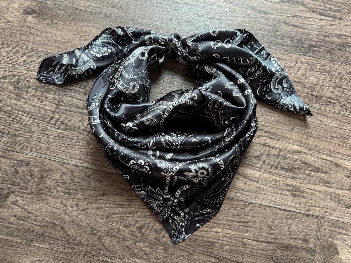 Black patterned scarf on a wooden surface