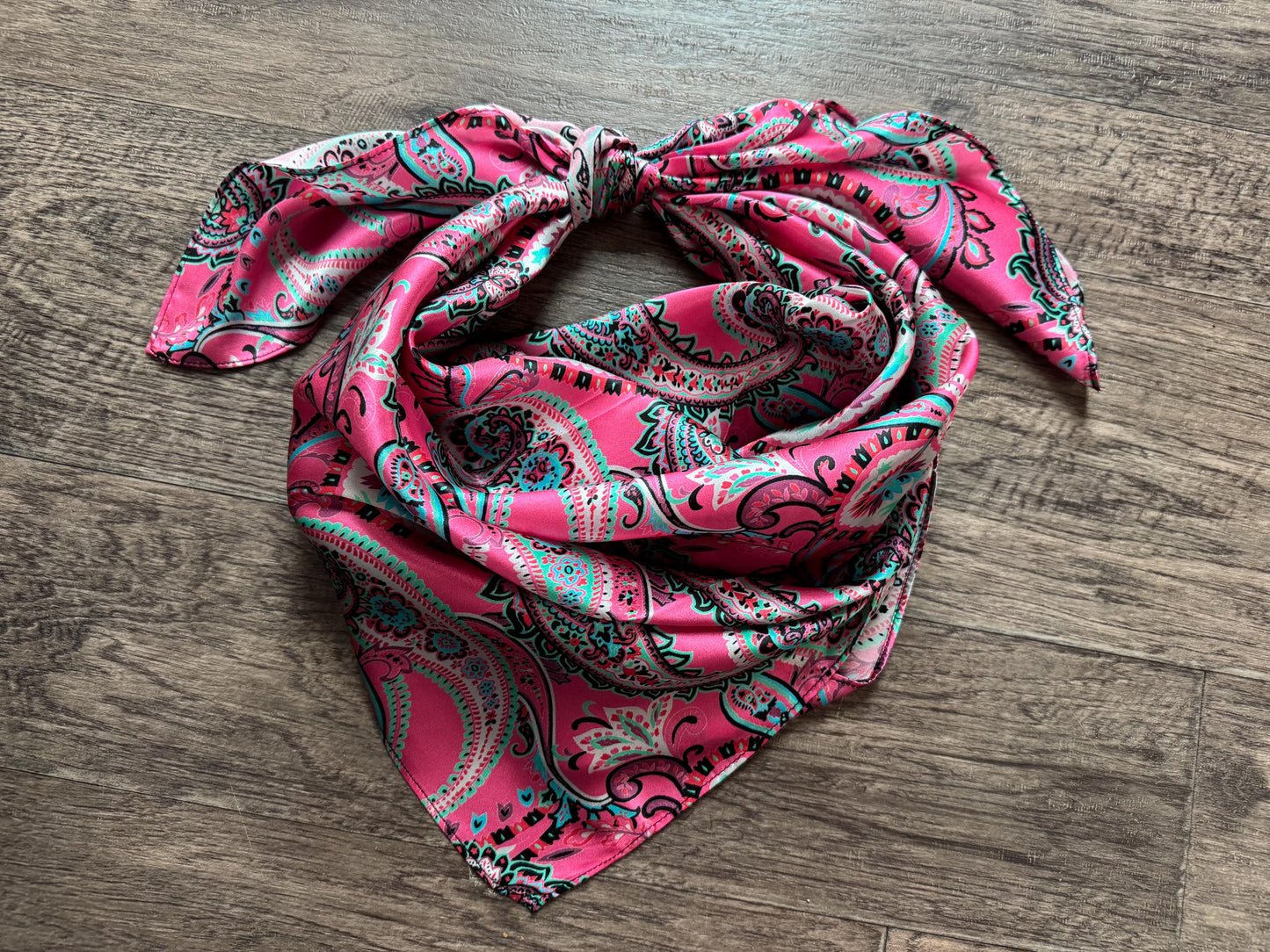 Pink paisley scarf on a wooden surface