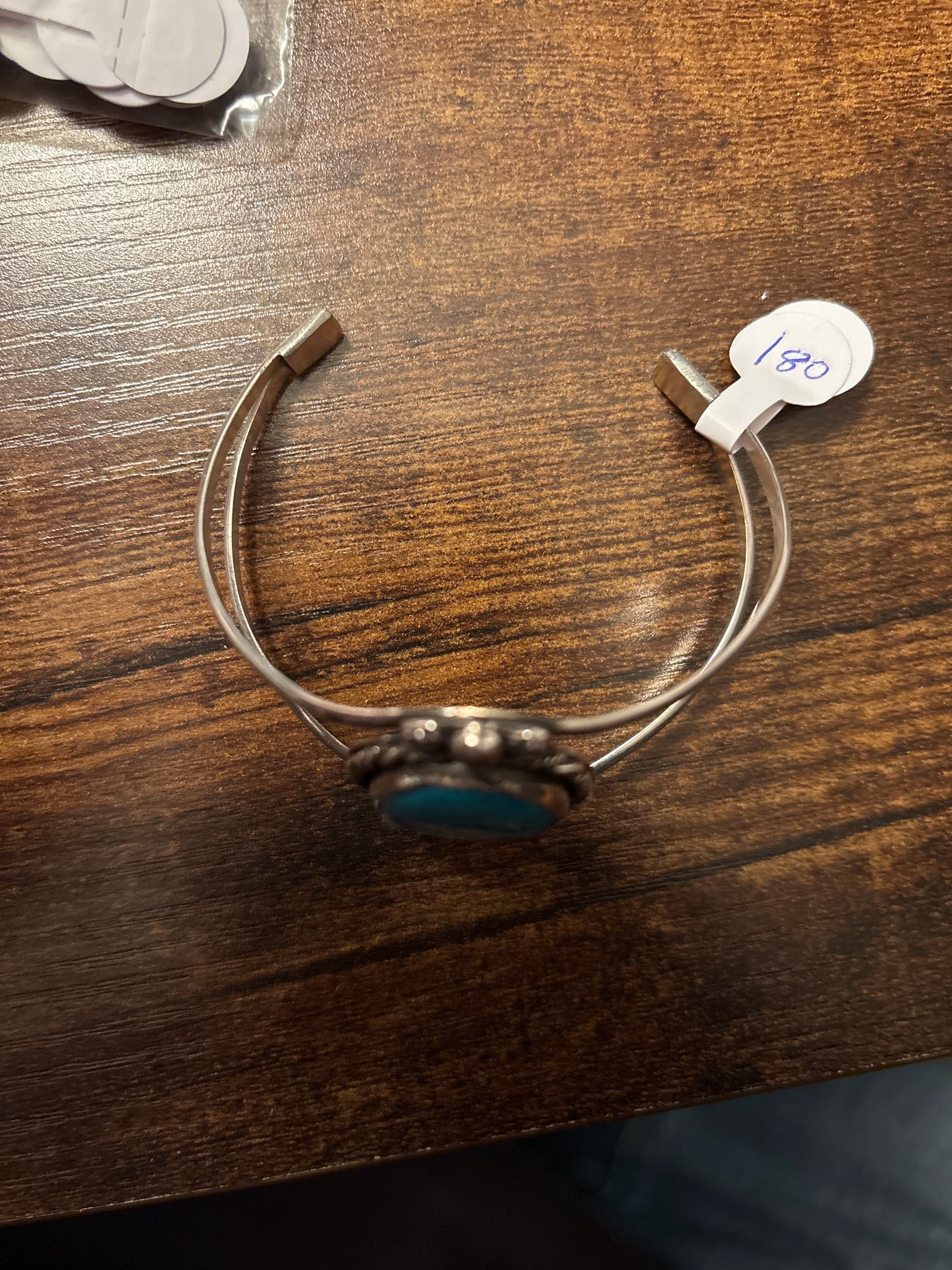 Silver bracelet with a blue stone on a wooden surface