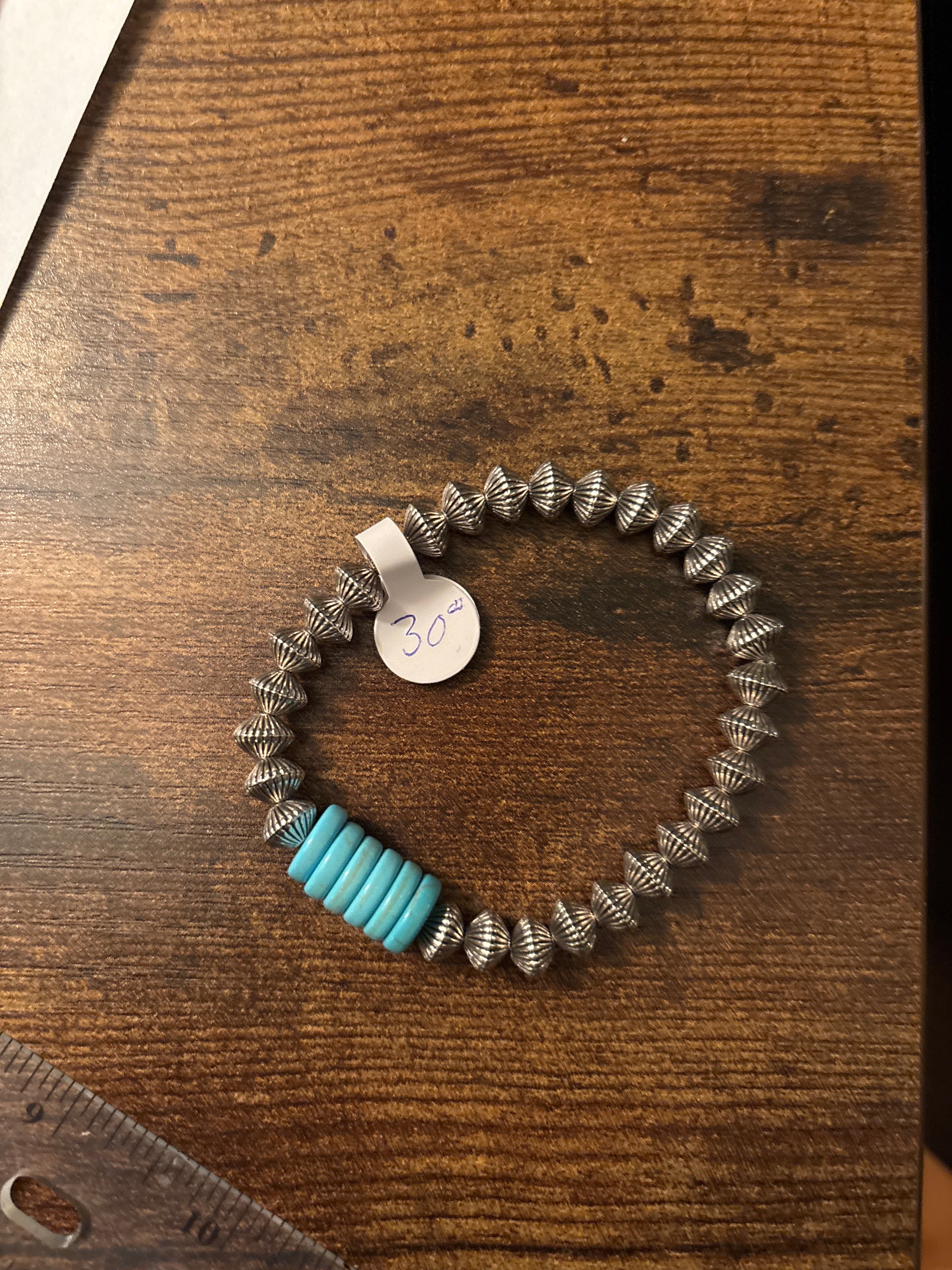 Bracelet with blue and silver beads on a wooden surface