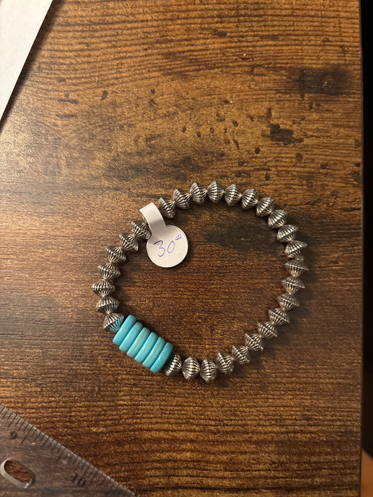 Bracelet with blue and silver beads on a wooden surface