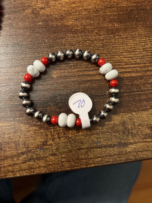 Beaded bracelet with black, white, and red beads on a wooden surface