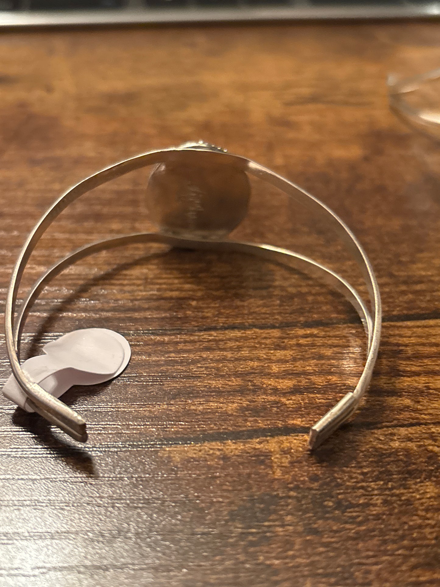 Metallic headband with a clip on a wooden surface