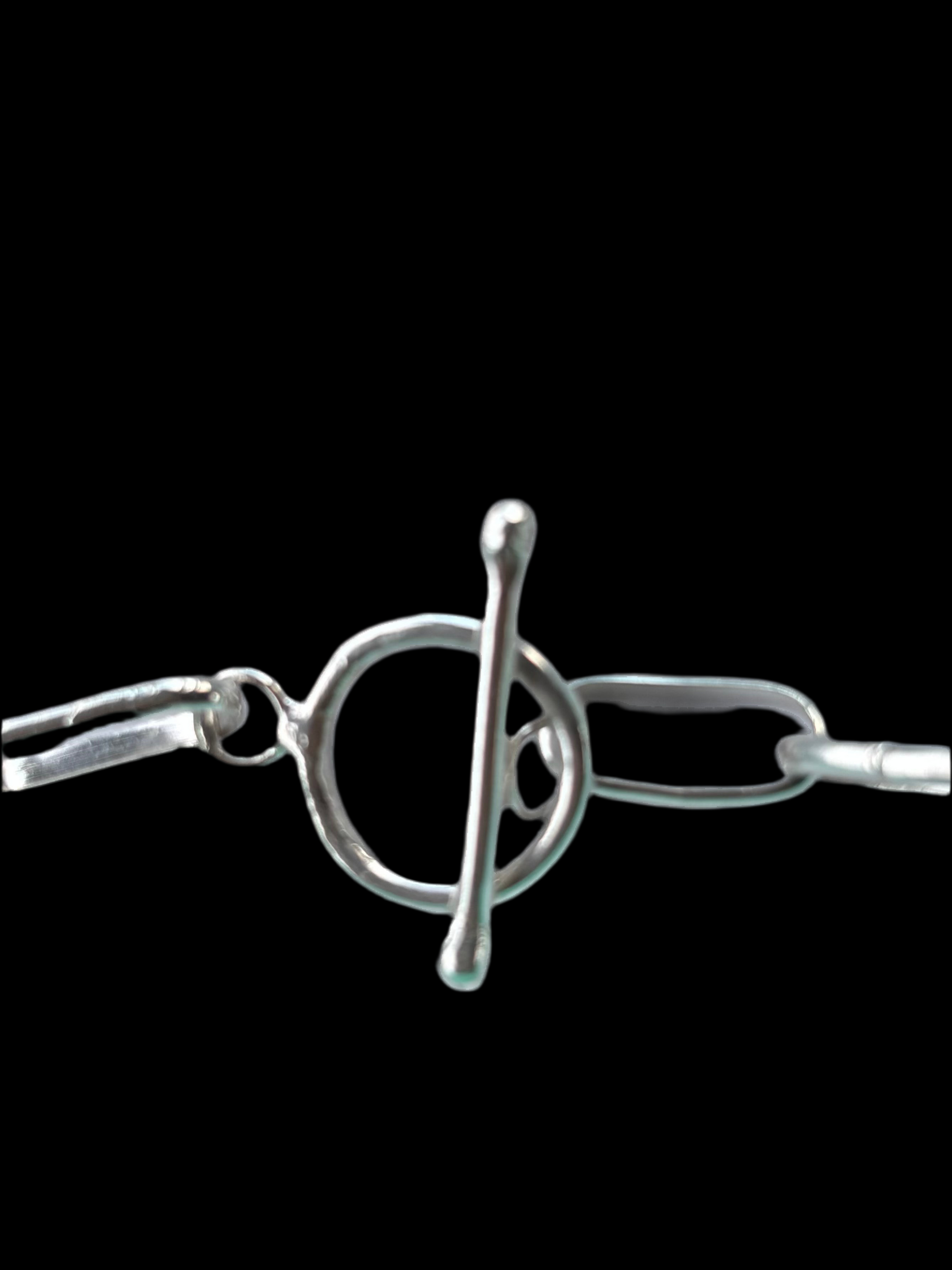 Silver bracelet with a unique design on a black background