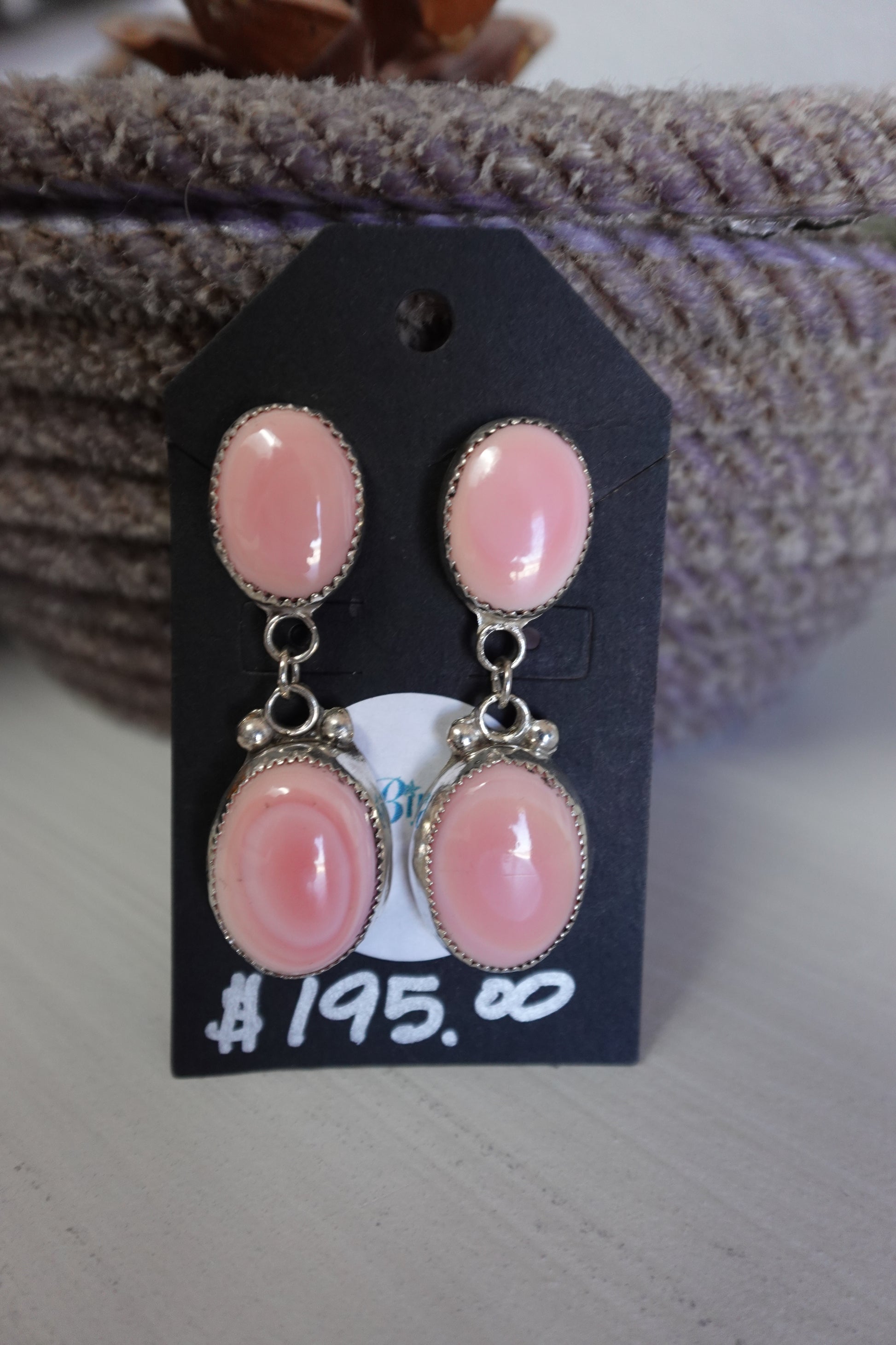 Pink earrings on a black price tag with a blurred background