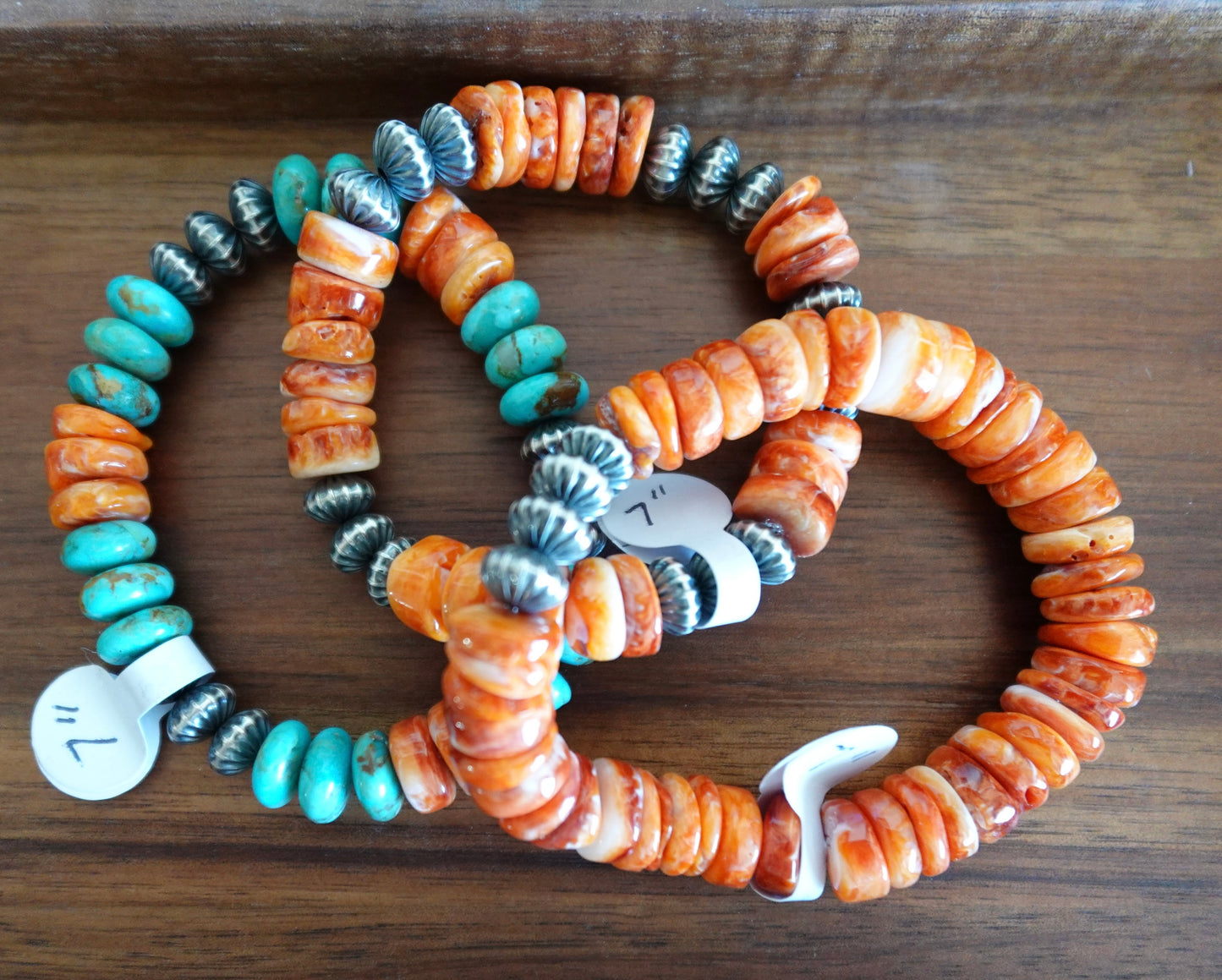 Three beaded bracelets on a wooden tray