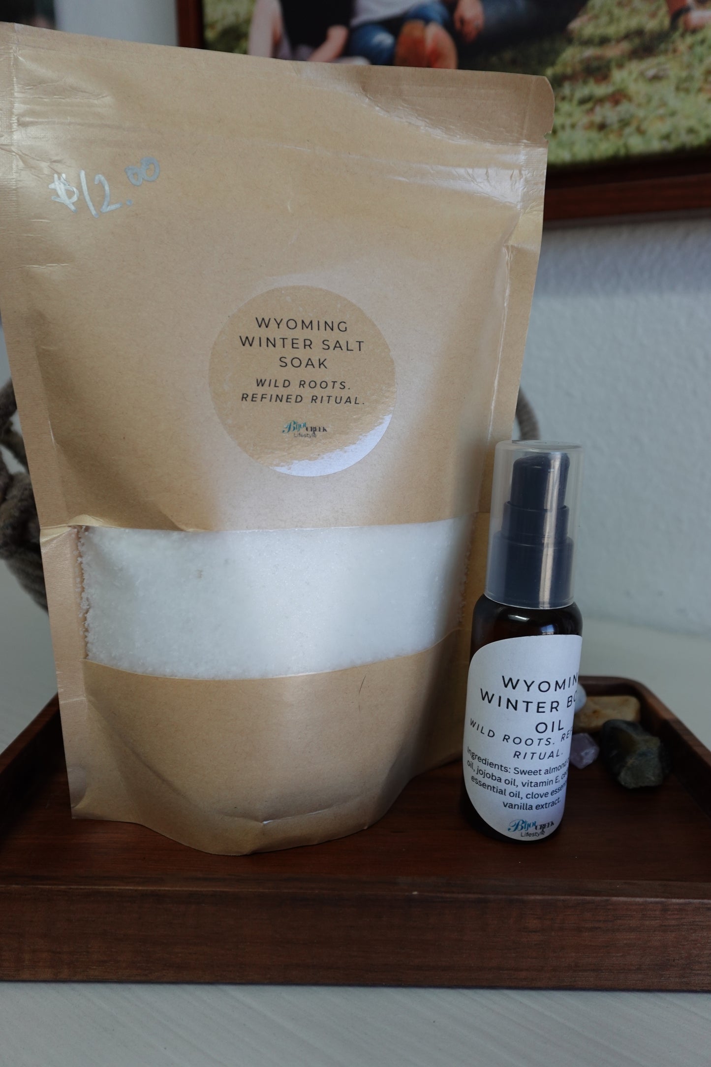 Bottle of winter body oil and a bag of salt soak on a wooden surface