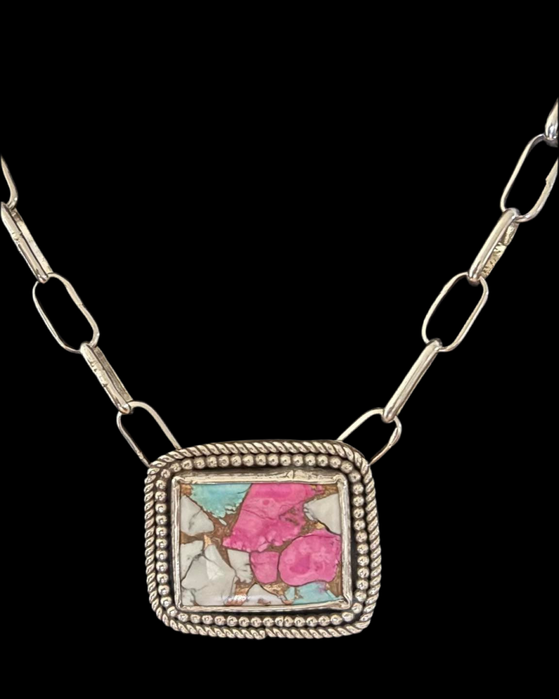 Necklace with a square pendant featuring pink and blue colors on a black background