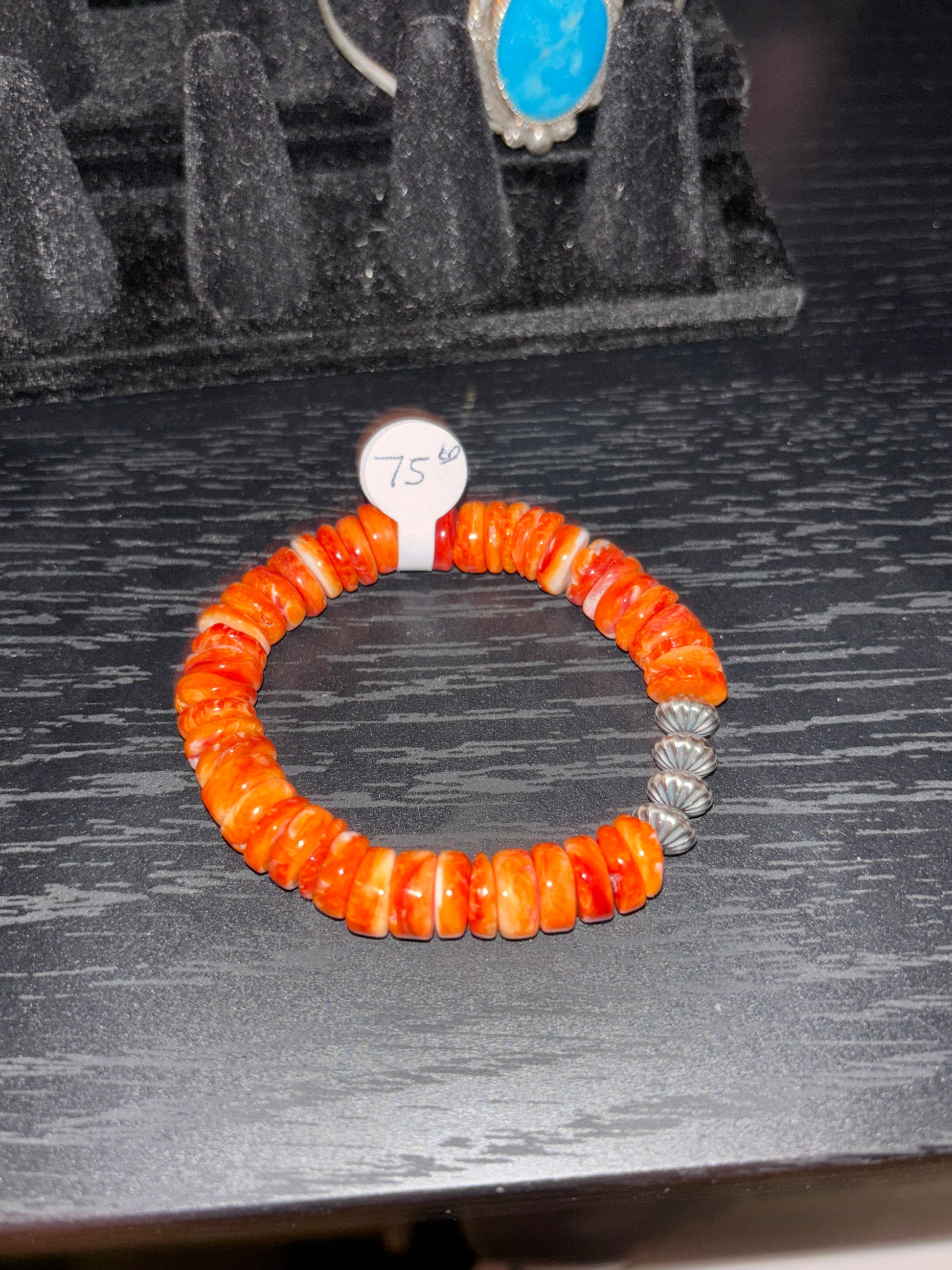 Orange beaded bracelet on a dark textured surface