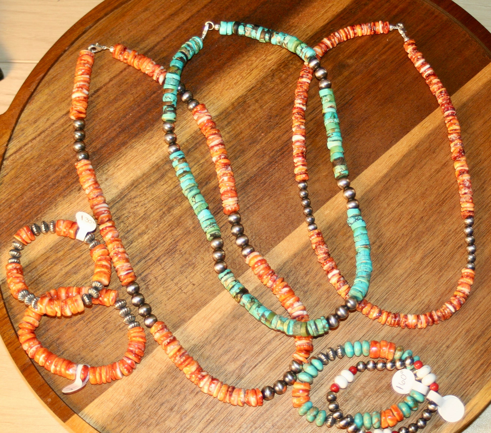 Three beaded necklaces on a wooden surface