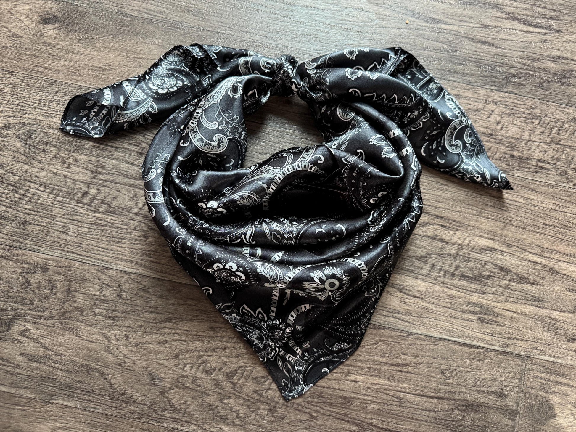 Black patterned scarf on a wooden surface