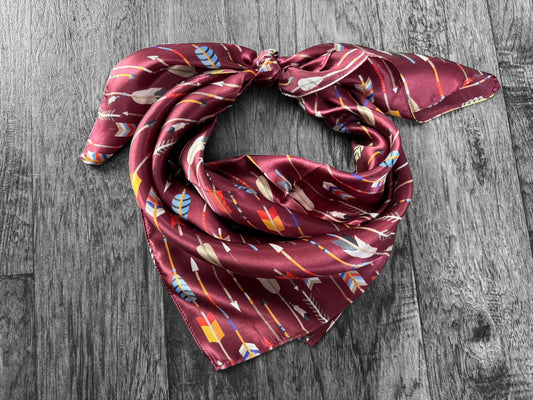 Maroon scarf with colorful patterns on a wooden surface