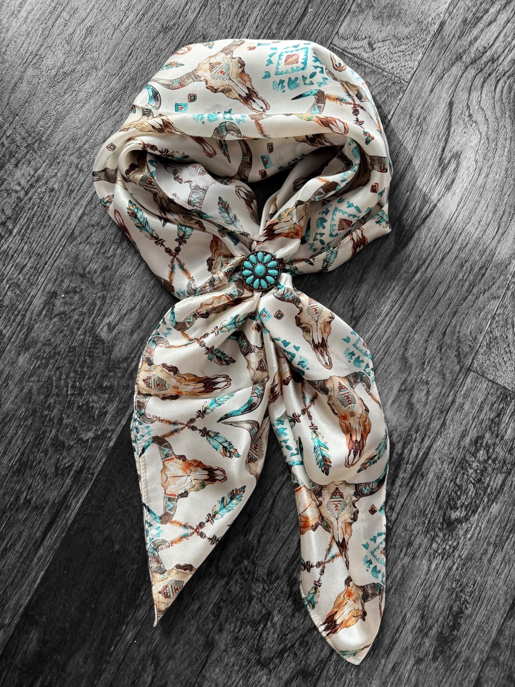 Decorative headscarf with a floral pattern and turquoise brooch on a wooden surface